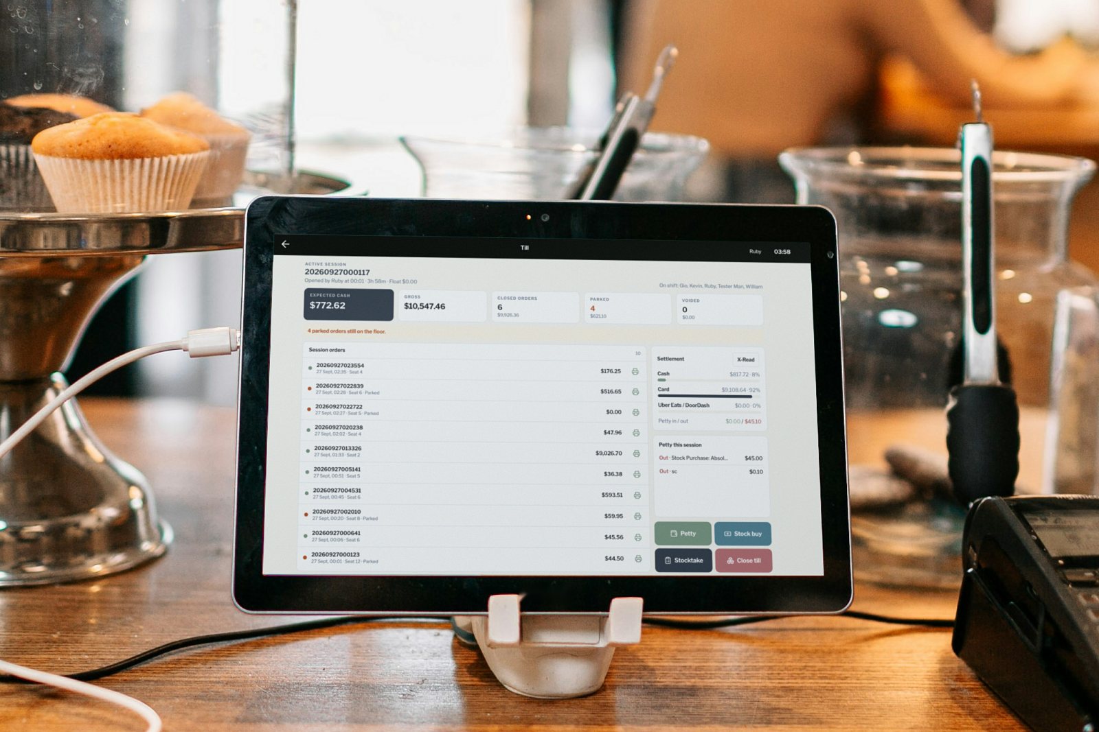 Tablet on a café counter showing an open till session: expected cash, session orders, settlement mix, petty cash and Close till